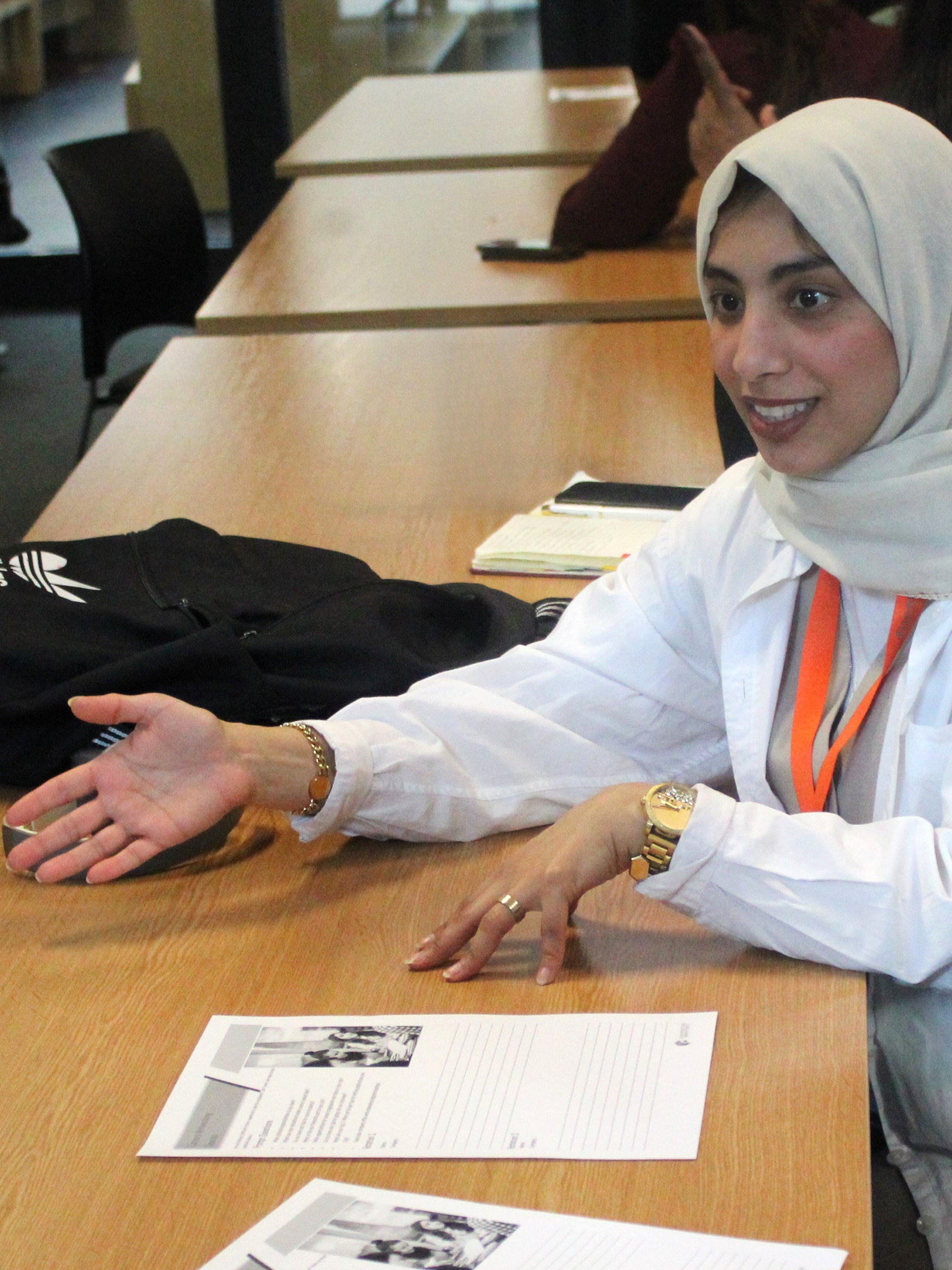 Construction Youth UK. A participant discusses printed documents at a classroom table during a workshop or group learning session.